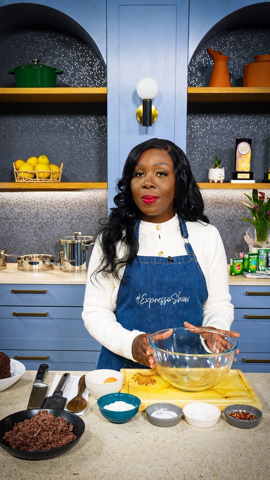 Clara Kapelembe Bwali cooking on the Expresso Show set on SABC3, wearing an Expresso Show apron