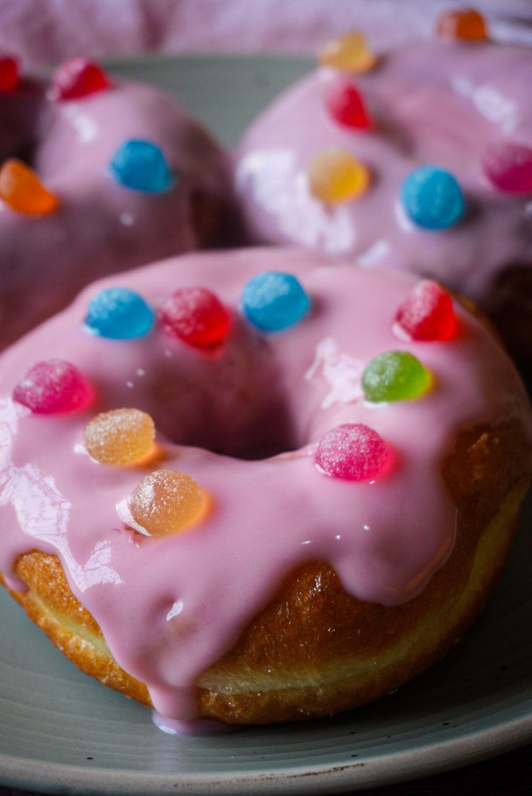 Close-up of a pink glazed doughnut topped with colourful gum drops for National Milling Corporation