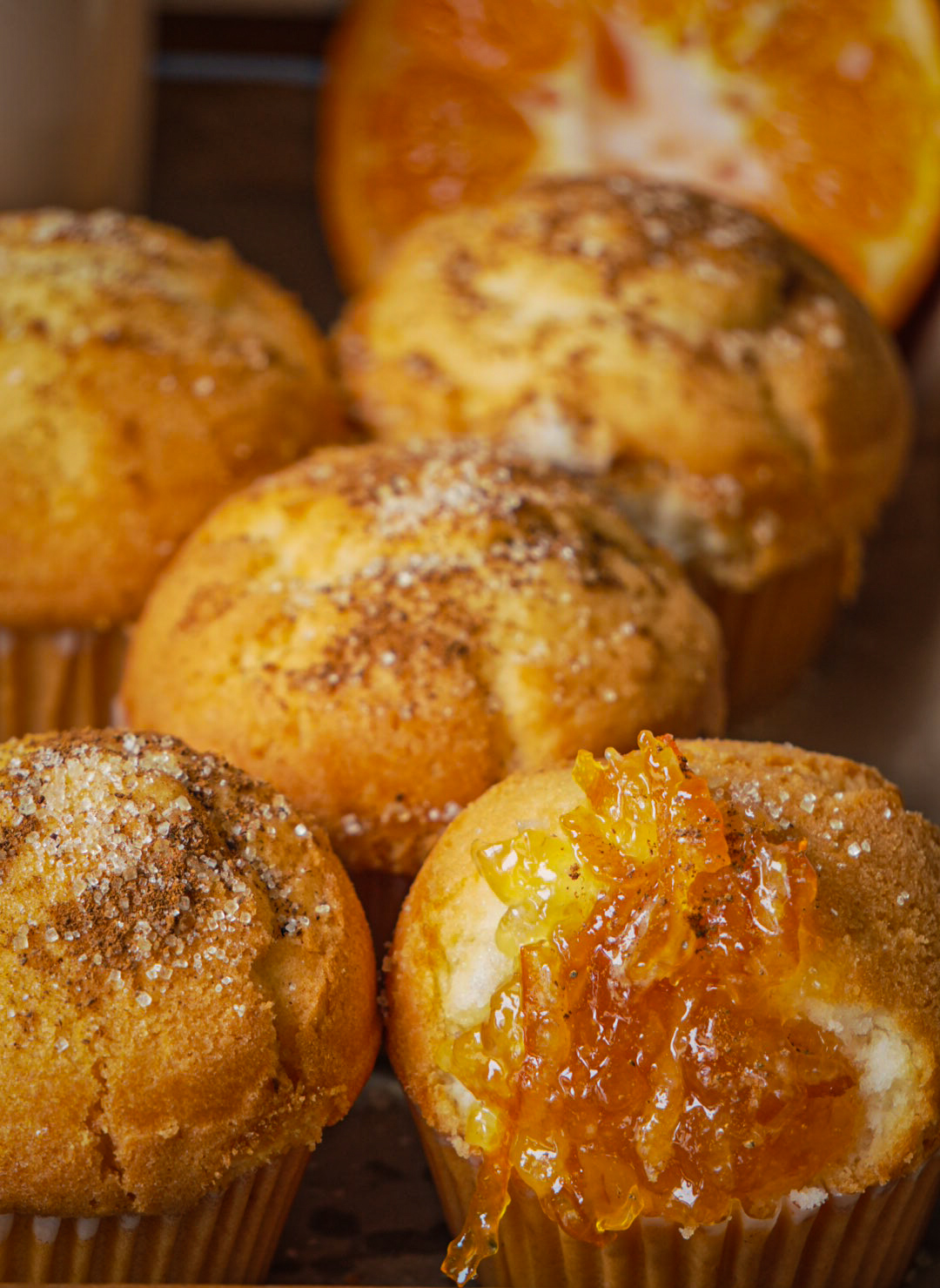 Close-up of cinnamon sugar doughnut muffins styled with fresh orange